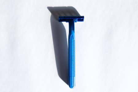 Blue men's razor on a white background. View from above.