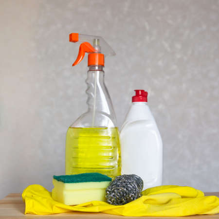 Bottled cleaning agent and dishwashing set are on the table.の写真素材
