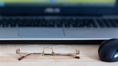 Glasses for vision lie on the laptop on desktop in the office.