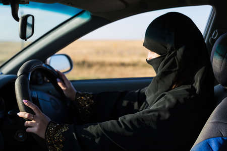 Serious islamic woman driver looking at roadの写真素材