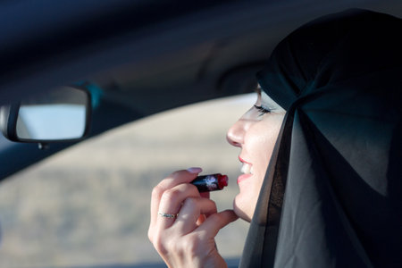 Muslim woman with lipstick in a car, traditional clothesの写真素材