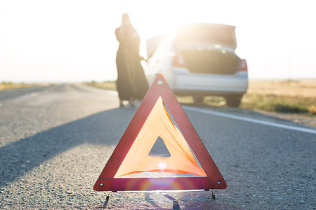 Car breakdown on the road, warning sign on the asphalt,
