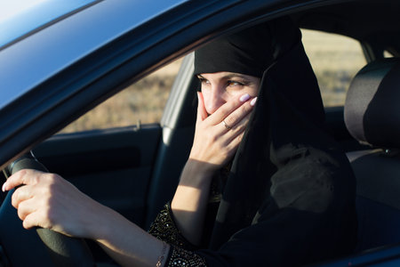 Woman driver scared while driving covered her mouth with her hand.,の写真素材