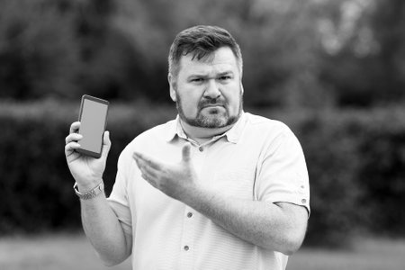 The man does not understand his new smartphone, does not know how to use. Black and white
