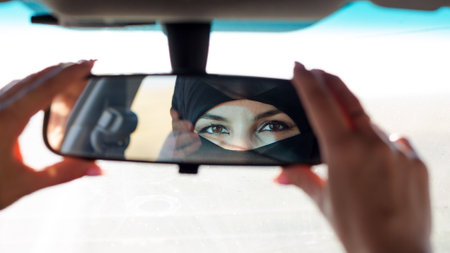 Muslim woman's eyes in the rearview mirror of a car.の写真素材