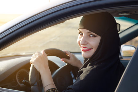Islamic woman taxi driver driving a car.,