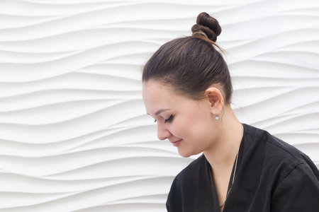 Portrait of a woman masseuse in a black robe white backgroundの写真素材