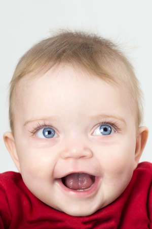 Child with wide open eyes looks directly on a white background.