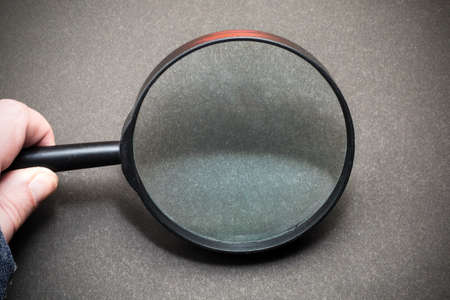Magnifying glass on a black background. Hand with magnifying glass.の写真素材