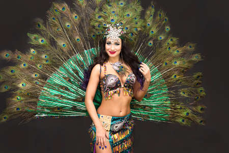 Woman oriental dancer peacock feather costume. Black backgroundの写真素材