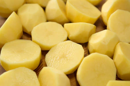 Coarsely chopped potatoes for cooking on wood board. Close-upの写真素材