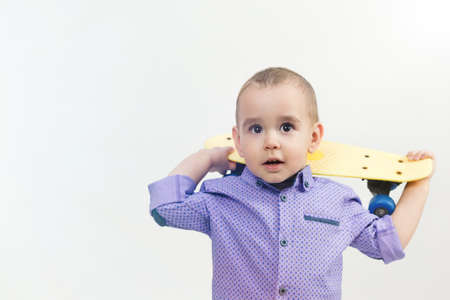 Preschool boy with skateboard on shoulder isolated white background.