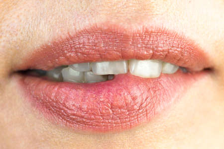 Girl sexually bites her lip with her teeth, macro photography.