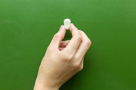 Female hand with chalk green board close up copy space.