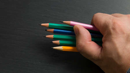 Several colored pencils in a man fist, Close-up.の写真素材