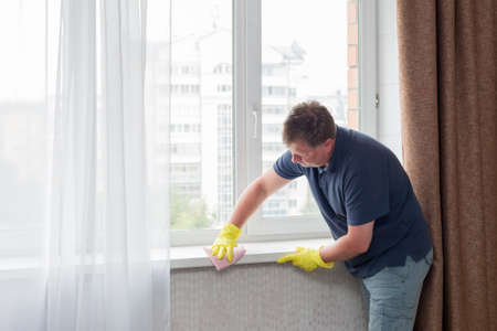 Lonely bachelor man tidies up the house before a date.の写真素材