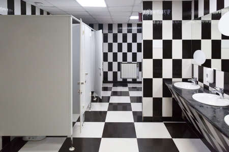 A bright creative toilet, interior is made of black and white tile.