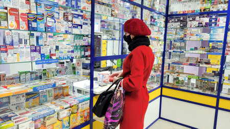 Orenburg, Russia - November 2, 2021 A woman in a red coat buys medicines at a pharmacy. Editorial .のeditorial素材