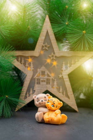 Handmade soap in form of a bear cub in an embrace with a tiger cub on the background of Christmas decorations.の写真素材