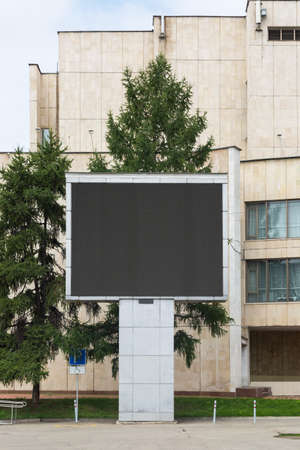 Faulty on-screen display for advertising on a city street against the background of a tall white building.の写真素材