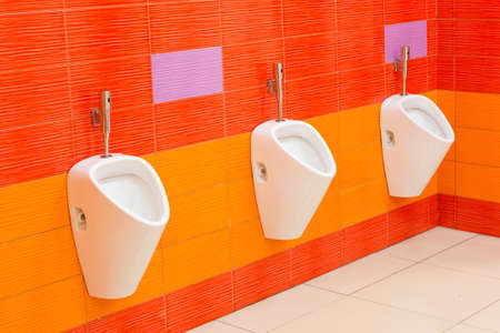 Creative men's toilet in bright orange colors in the mall.の写真素材