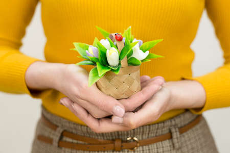 small basket with white handmade soap snowdrops on a woman's hand.