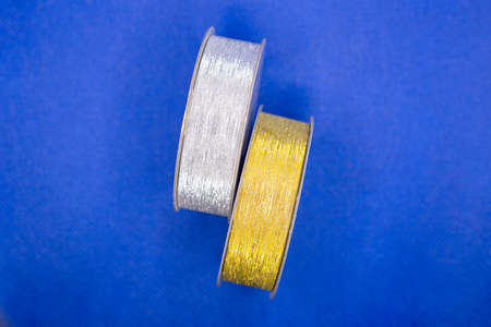 Two packing tapes in gold and silver blue background.