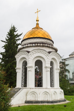 Russia, Irkutsk - July 31, 2021 An old white chapel with a golden dome and a cross on the outskirts of the city. editorialのeditorial素材