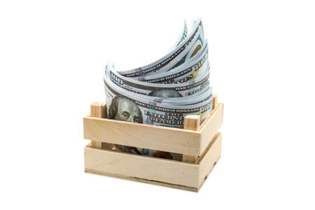 Paper money lies a small wooden box isolated, white background.の写真素材