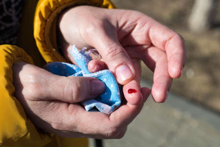 A drop of blood wounded female finger, Concert of an accident on the street.の写真素材