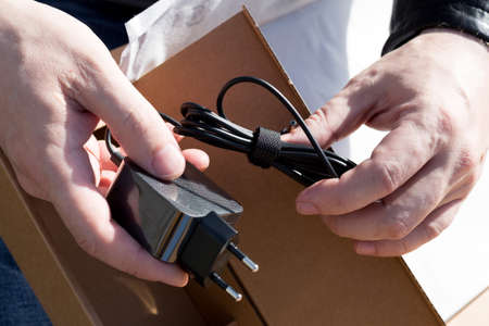 New laptop charger in male hands.