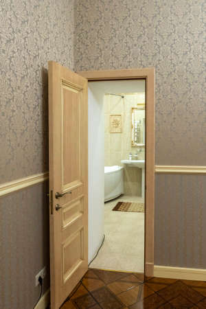 Open wooden door to the bathroom in the apartment.の写真素材