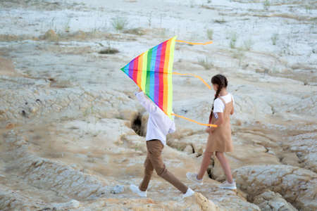 Children carry kite in their hands, tired return home from a walk.の写真素材