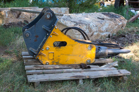 A large detail of construction equipment, a jackhammer lies on a pallet.の写真素材