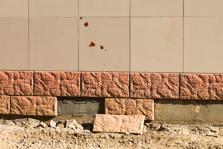 Decorative facing stone falls off from the wall building.