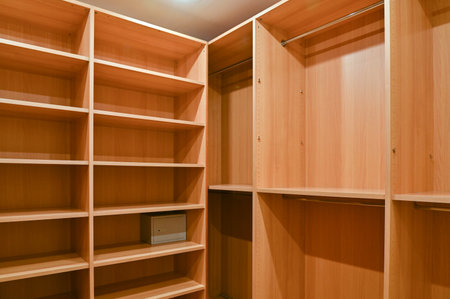 Wardrobe room in an apartment with wooden cabinets for storing clothes.の写真素材
