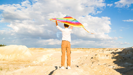 A boy of 8-9 years old happily launches kite into the sky.の写真素材