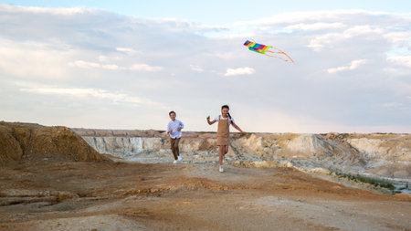 Children play active games with kite outdoors.の写真素材