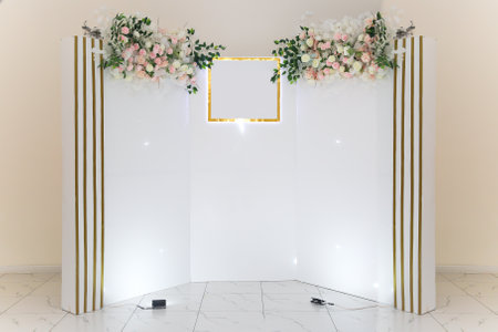 White photo zone with delicate flowers for the hero of the day in the cafe.