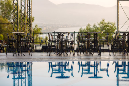 Empty tables and chairs near the open outdoor concert stage on the seashore.の写真素材