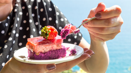 Strawberry cake plate in female hands against the backdrop of the sea. Decorating cakes with whole berries.の写真素材