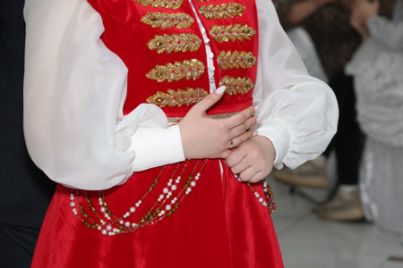 A bride in a white and red national costume is worried holding her finger at the marriage registration.の写真素材