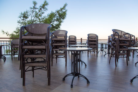 Chairs stand on top of each other, early morning in a street cafe.
