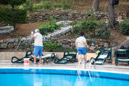 Alanya, Turkey - October 02, 2022 Utopia World hotel, workers clean garbage near the pool,...