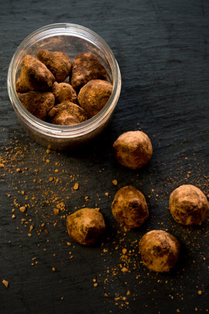 Portioned sugar scrub in the form of chocolate truffles on black backgroundの写真素材