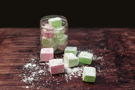 Colored portion scrubs in the form sweets oriental sweets sprinkled with corn starch on a wooden backgroundの写真素材