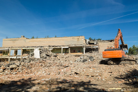 excavator eliminates consequences of an earthquake, clearing rubble from residential buildings.