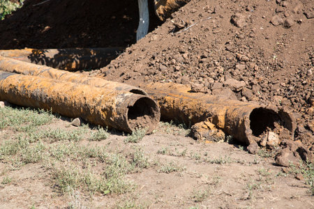 Replacement the city water supply, old rusty pipes among the heaps of earth.の写真素材