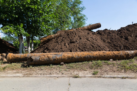 Replacement of the city water supply, old rusty pipes among the heaps earth.の写真素材