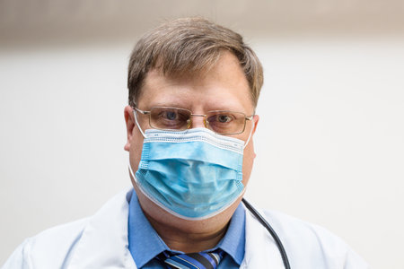 Portrait of a doctor protective mask on his face, close-up.の写真素材